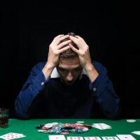 Man is playing poker. Emotional fail in game