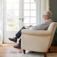 Senior man sitting in an armchair doing sudoku