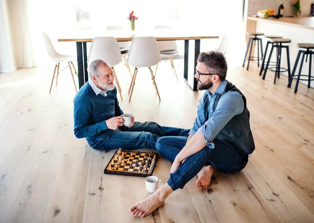 son and senior father playing chess