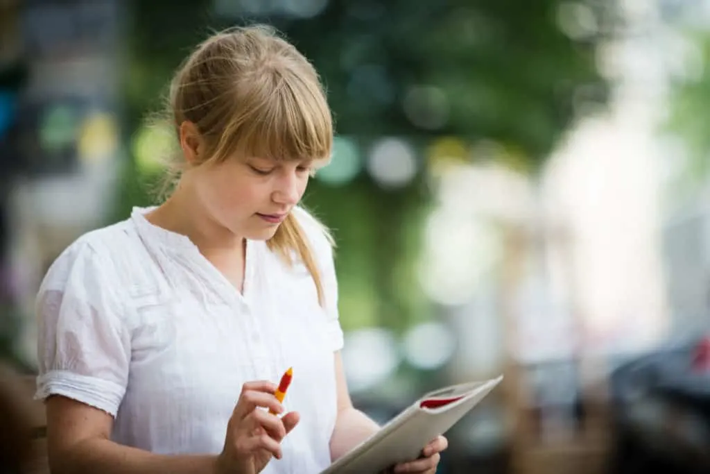 woman doing crosswords outdoors sudoku