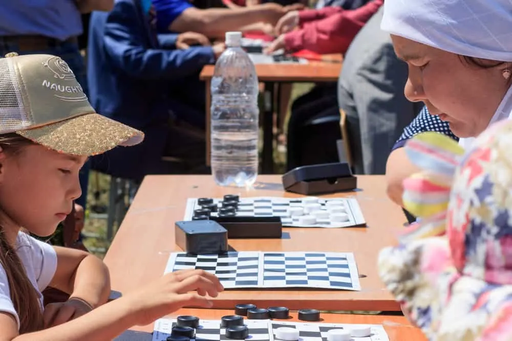 Girl and woman playing checkers