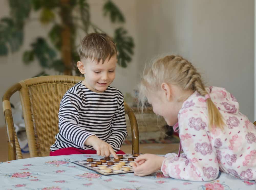 girl and boy playing checkers or draughts together