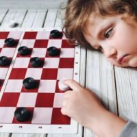 sad child plays checkers