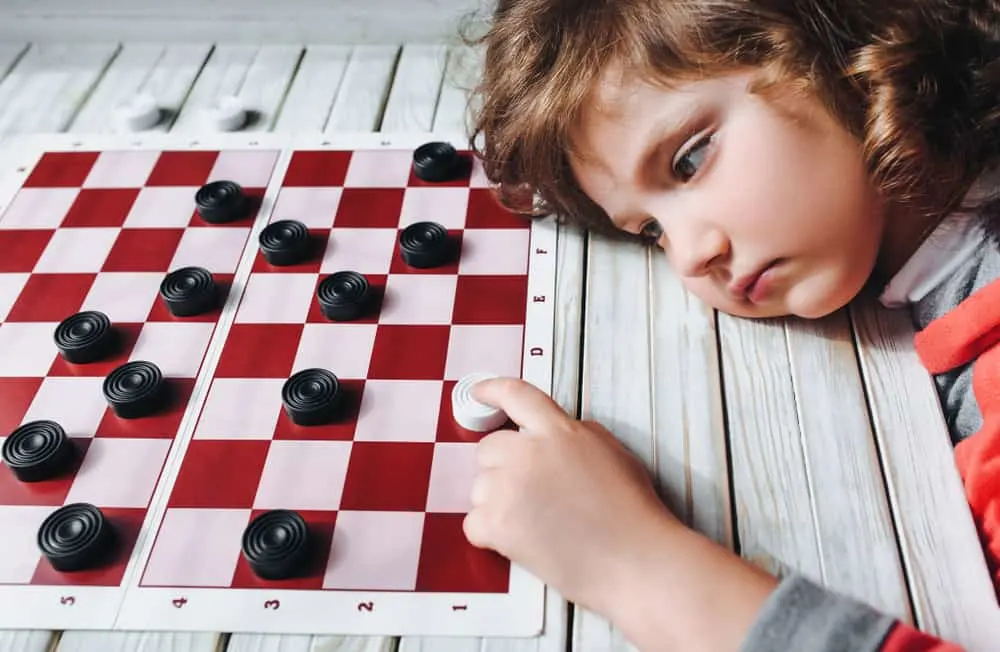 sad child plays checkers