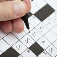 A person is doing a crossword puzzle with word stress