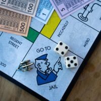 A diagnoal view of the Monopoly board and a player landing on the Go to Jail square