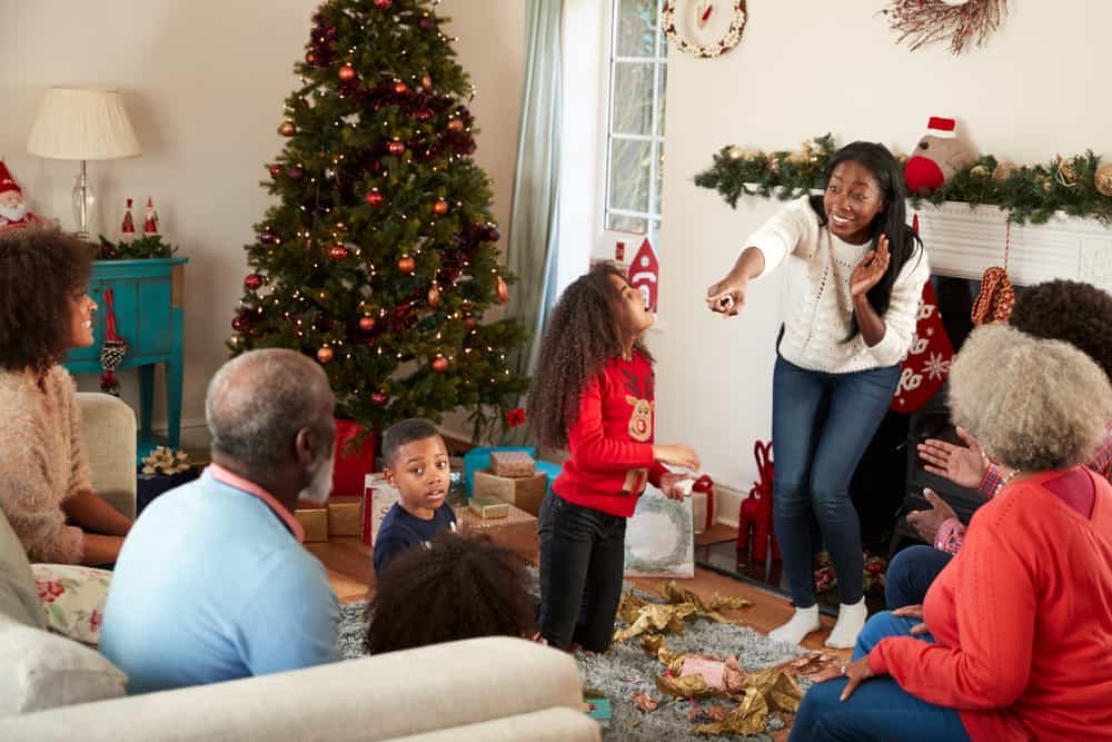 Family Playing Game Of Charades As They Celebrate Christmas At Home Together