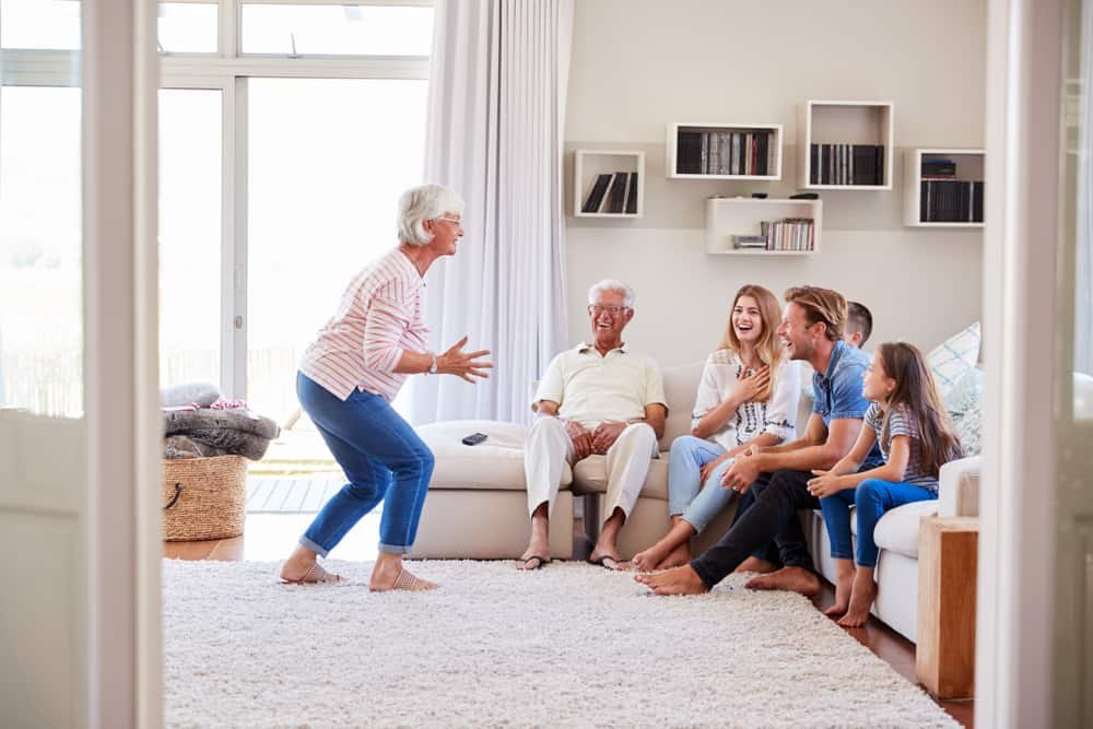 Family Sitting On Sofa At Home Playing Charades