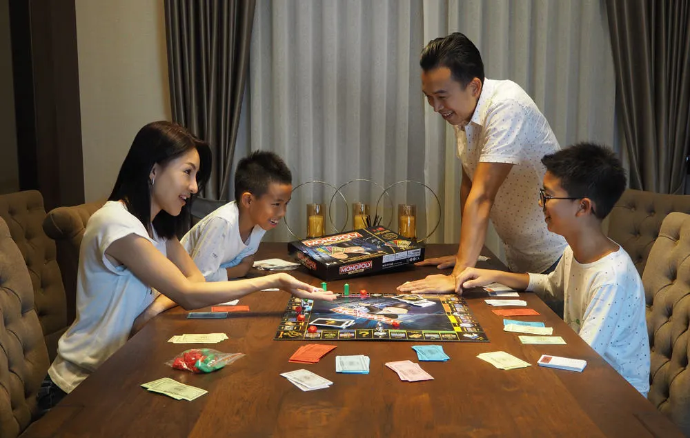 Family playing Monopoly board game together