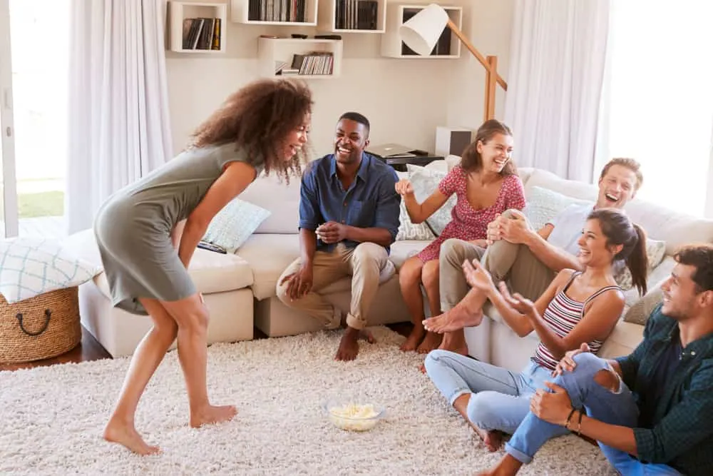 Group Of Friends Laughing and Having Fun Playing Charades Together