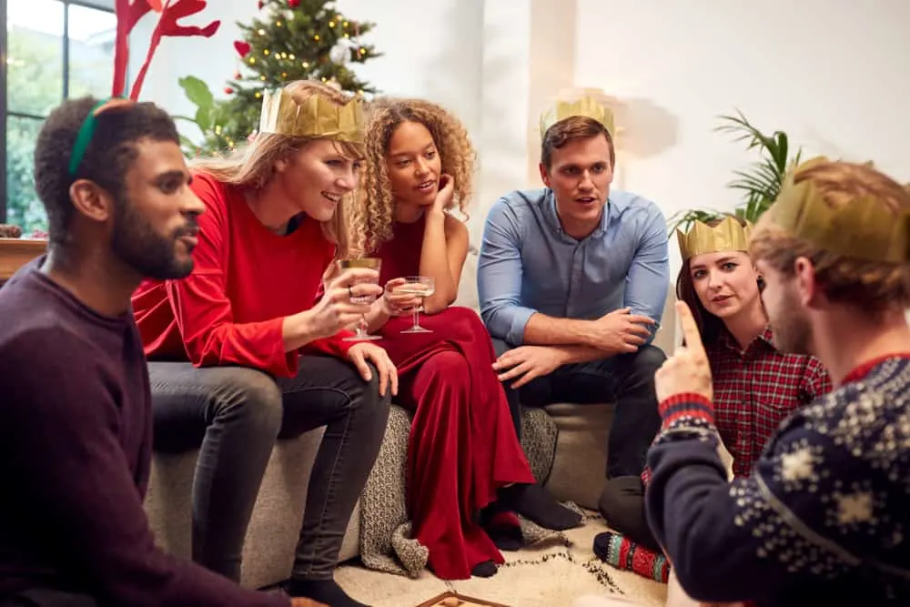 Group Of Friends Playing Charades After Enjoying Christmas Dinner