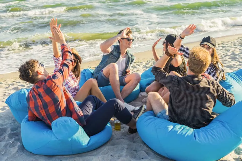 group of friends on the beach sitting on bean bags