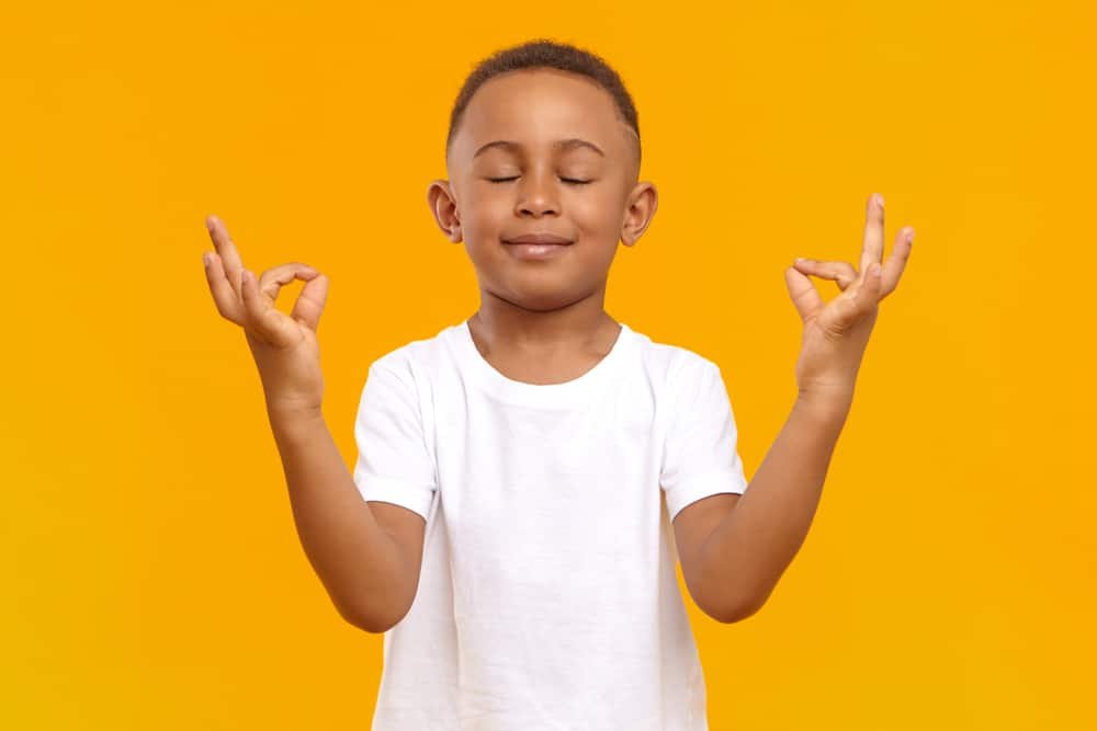 Boy with eyes closed and smiling, meditating