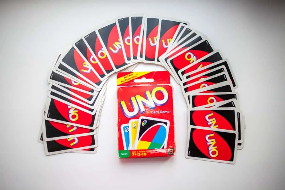 box of Uno card game and cards on white background