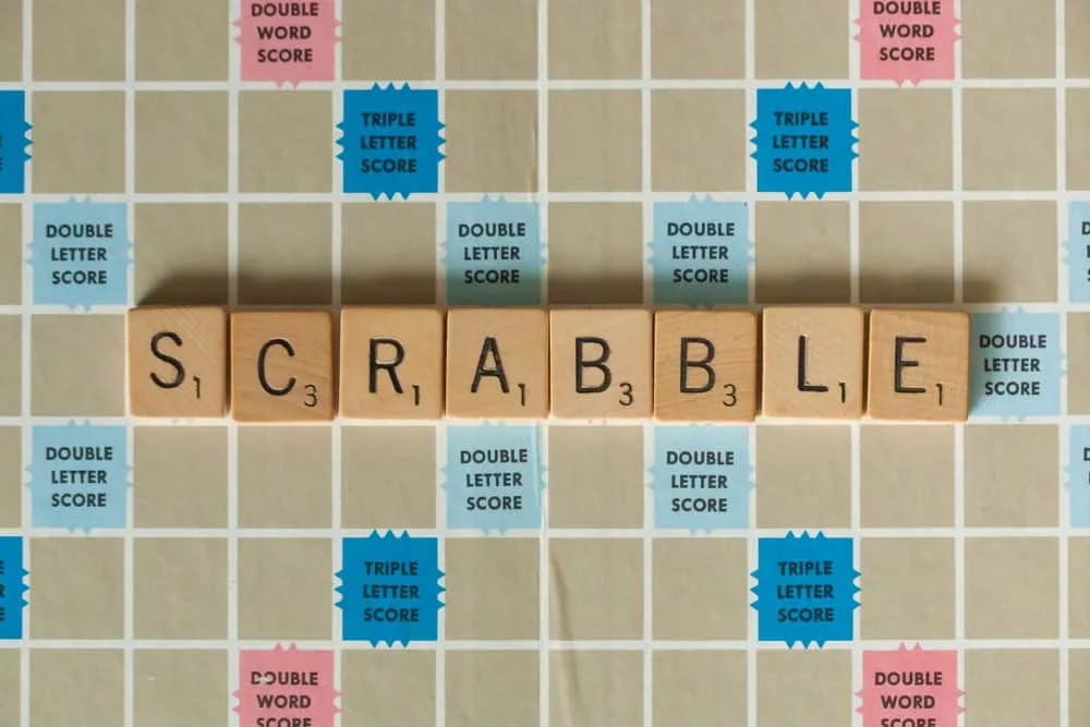 A vintage Scrabble board game is shown with letter tiles spelling out Scrabble