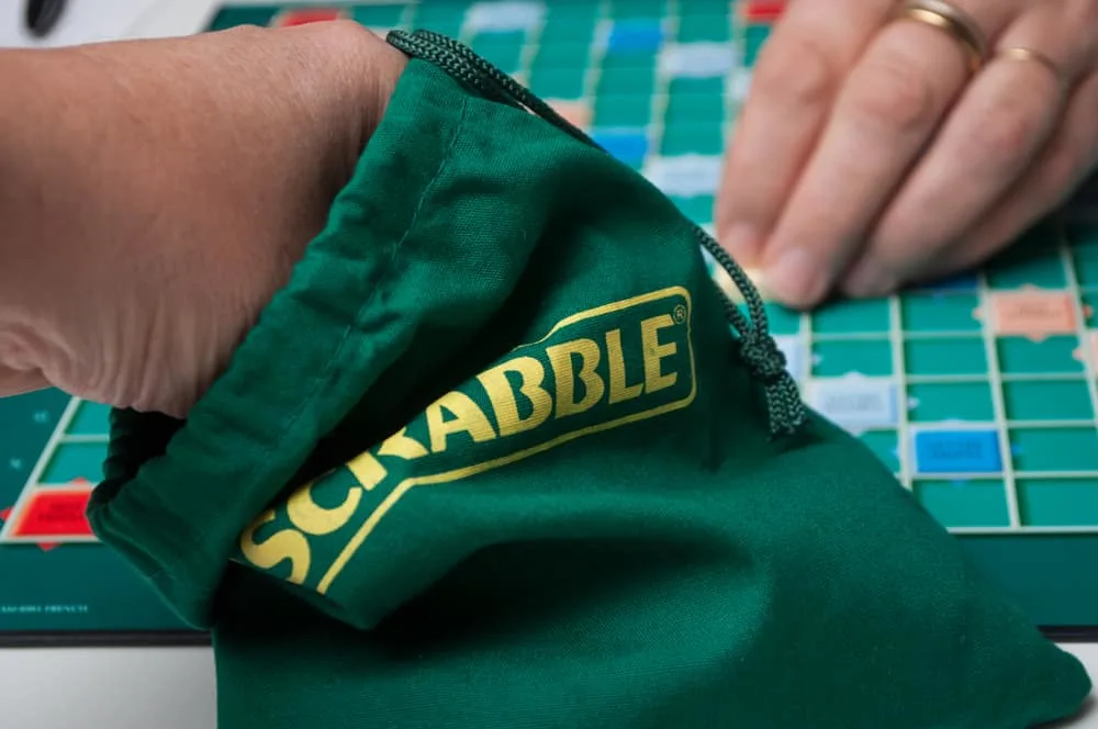 Closeup of player drawing a letter from green Scrabble bag