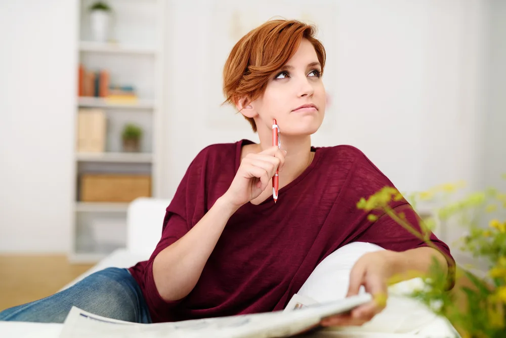 Woman Answering Crossword Puzzle Game on Newspaper