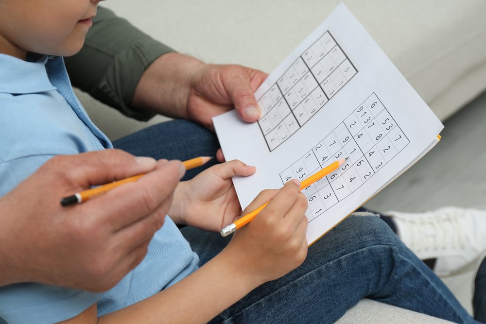 boy with his grandfather solving sudoku 