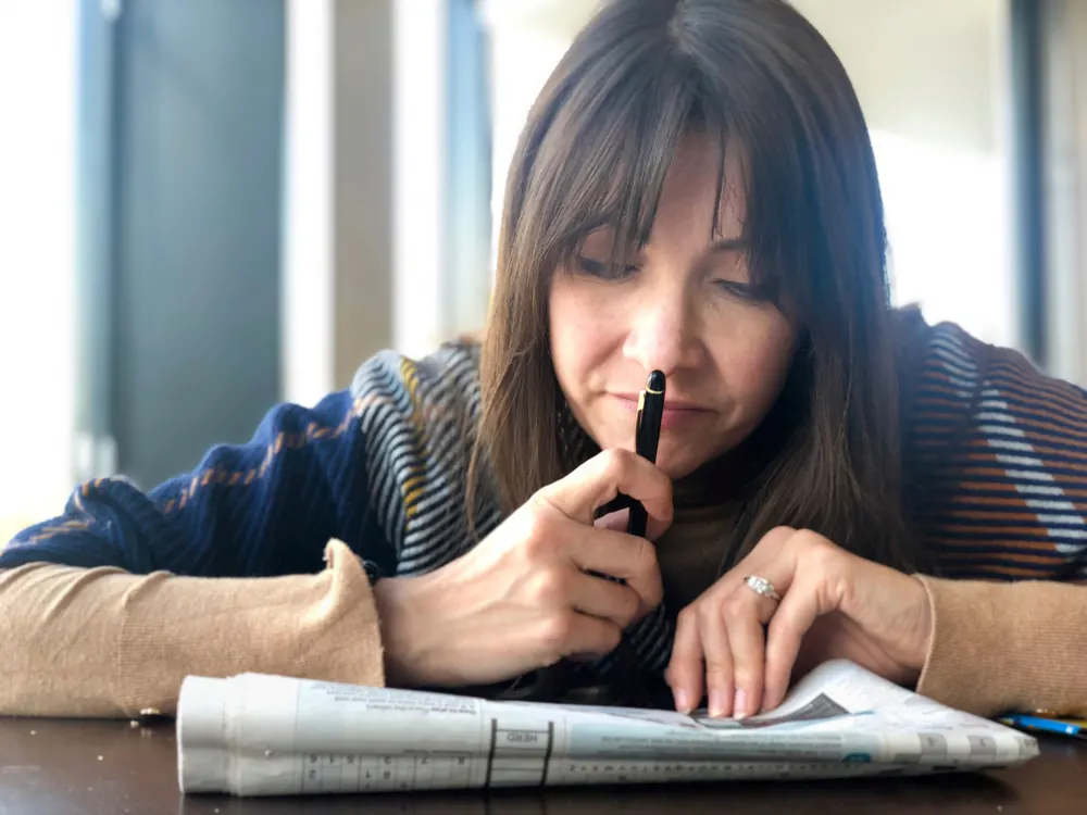 woman deep in thought while doing sudoku