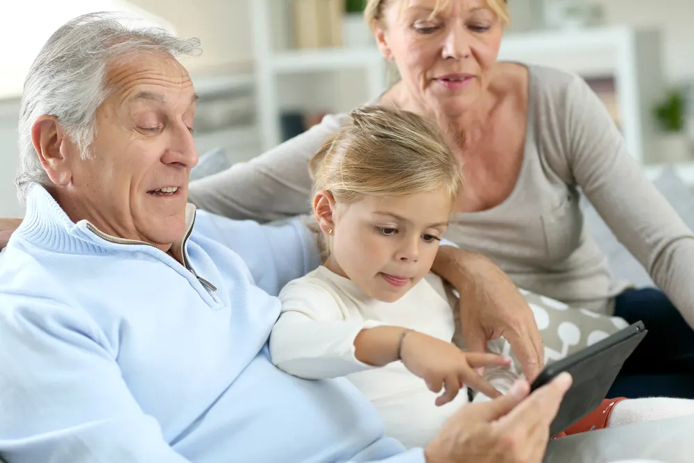 Grandparents with little girl using digital tablet