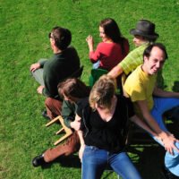 Six friends playing the game musical chairs