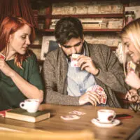 Three friends playing card game.