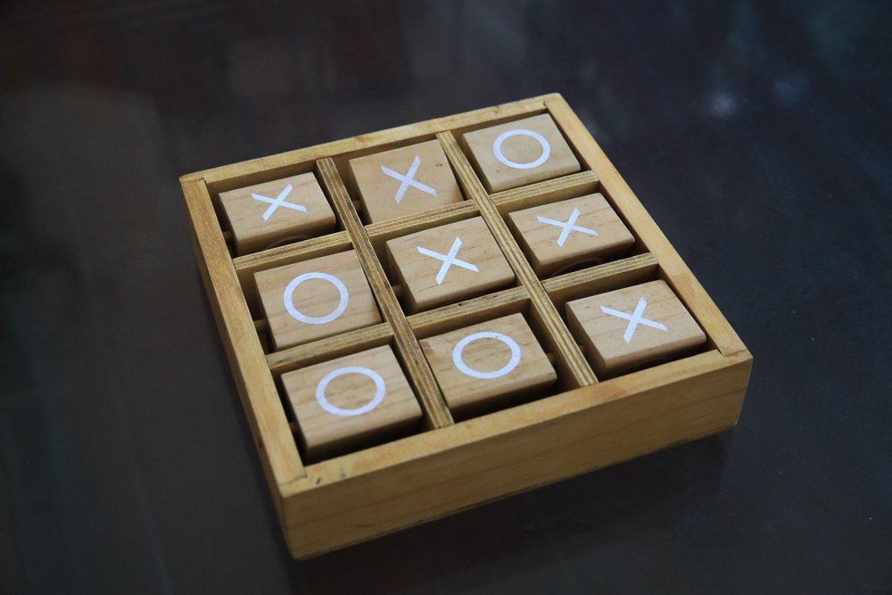 Wooden Tic-Tac-Toe game on the black desk