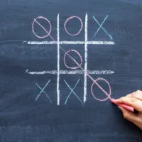 hand drawing a game of tic tac toe with colored crayons