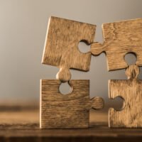 Four brown pieces of puzzle stand on wooden table