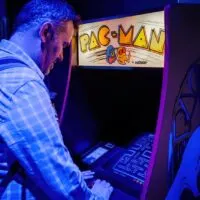 Man playing with pac-man arcade console
