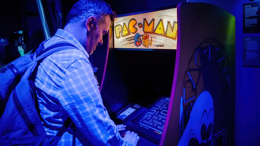 Man playing with pac-man arcade console