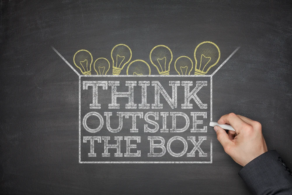 Think outside the box concept on black blackboard