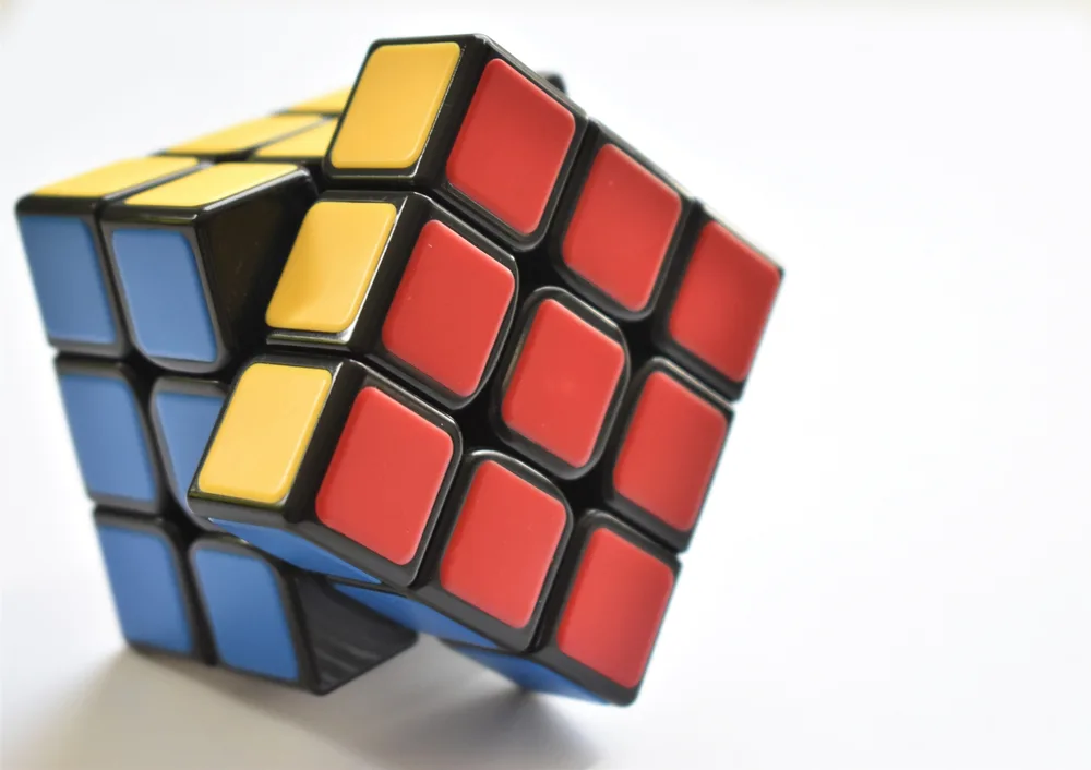 an almost solved Rubik's Cube on a white background