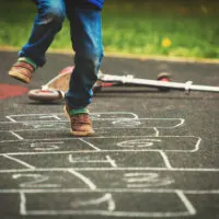 boy playing hopscotch on playground